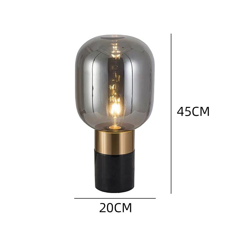 Lampe de table design Lumeoo avec globe en verre fumé, base dorée et socle noir, hauteur 45 cm