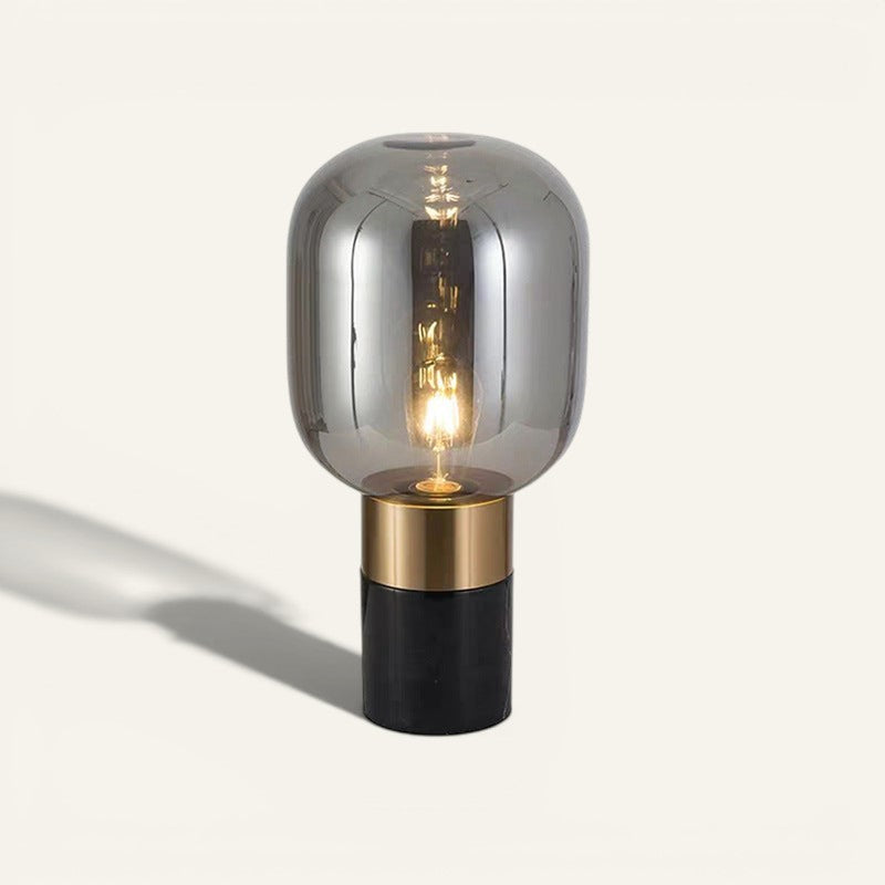 Lampe de table design Lumeoo avec globe en verre fumé, base en métal doré et socle noir, hauteur 45 cm