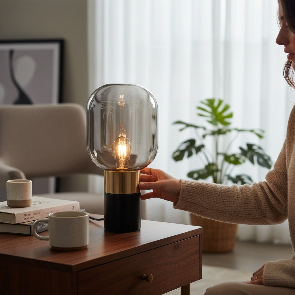 Lampe de table design Lumeoo avec globe en verre fumé, base noire et dorée, posée sur une table en bois