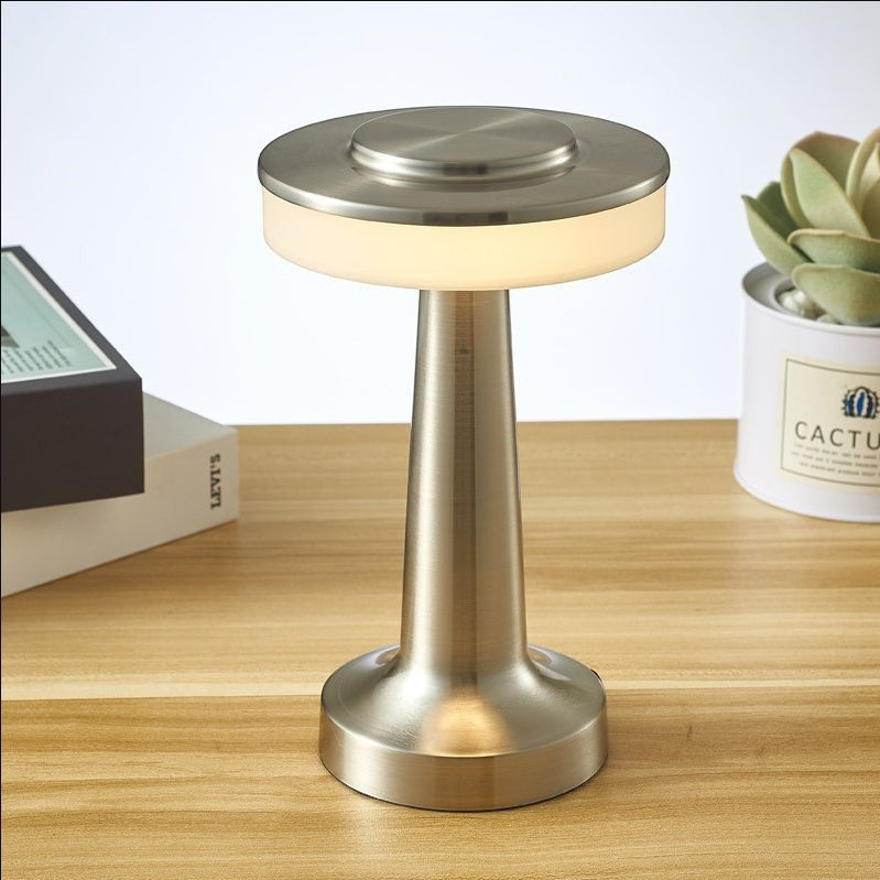 Lampe de table sans fil Lumeoo au design doré élégant avec éclairage LED diffus posée sur un bureau en bois