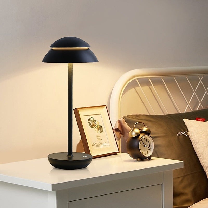 Lampe de table Lumeoo SKANDOR noire au design nordique minimaliste, rechargeable et sans fil sur une table de chevet.