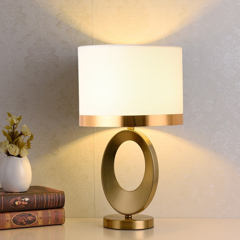 Lampe de table Lumeoo ORBILUX en métal doré avec pied ovale et abat-jour blanc pour salon ou chevet