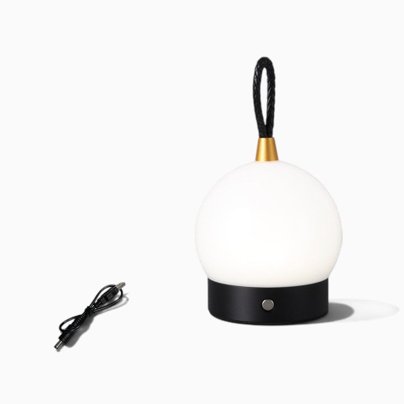 Lanterne nomade rechargeable Lumeoo au design sphérique blanc avec base noire et poignée en cuir tressé