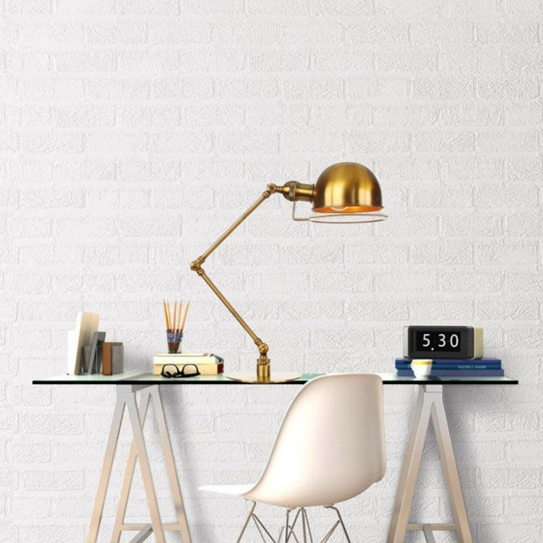 Lampe de table Lumeoo rétro en fer forgé doré avec bras articulé réglable sur un bureau moderne