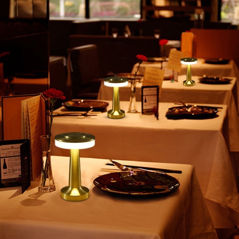 Lampe de table sans fil Lumeoo en métal doré, design LED tactile et dimmable pour une ambiance chaleureuse au restaurant.