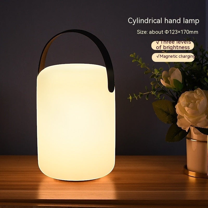 Lanterne camping LED Lumeoo rechargeable, cylindrique avec anse noire, diffusant une lumière douce sur une table