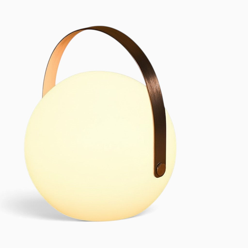 Lanterne camping LED rechargeable Lumeoo ronde avec anse en métal bronze diffusant une lumière douce et chaleureuse
