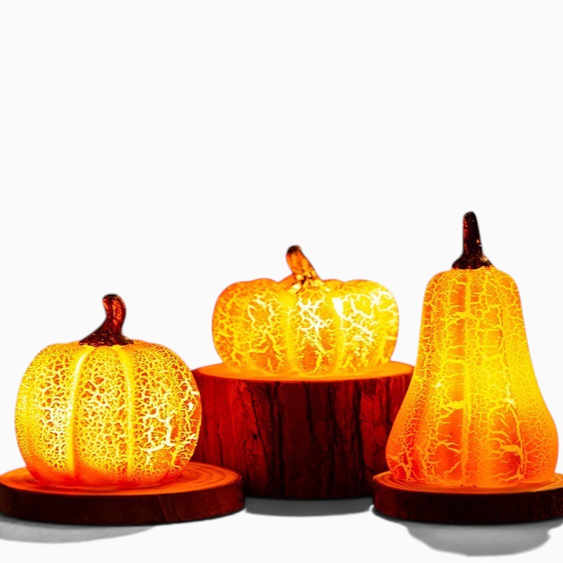 Trois lanternes citrouilles Lumeoo en résine effet craquelé avec éclairage LED chaleureux sur des socles en bois