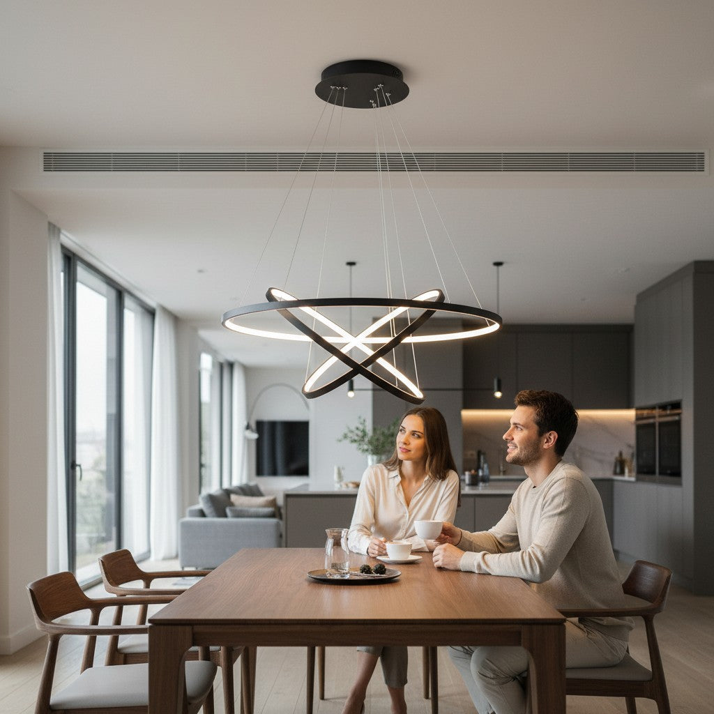 Lustre LED Lumeoo CIRCOLUX en forme d'anneaux croisés noirs suspendu au-dessus d'une table à manger dans un salon moderne