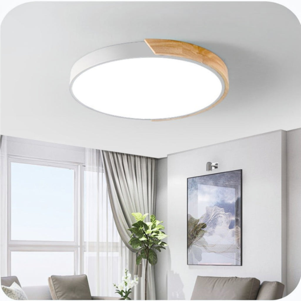 Plafonnier LED rond Lumeoo au design scandinave blanc et bois, diffusant une lumière douce dans un salon moderne.