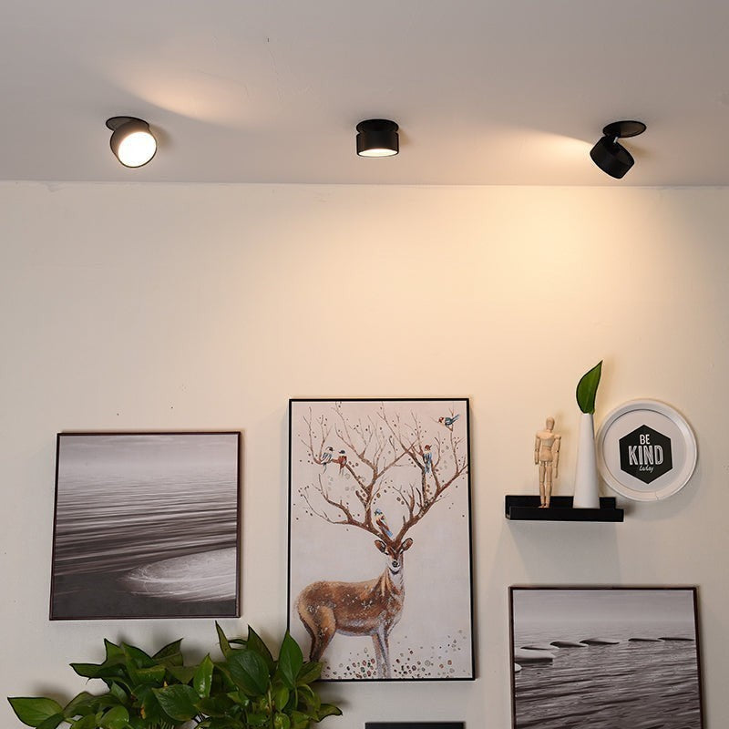 Trois spots LED Lumeoo encastrables noirs orientables installés au plafond pour éclairer des cadres décoratifs