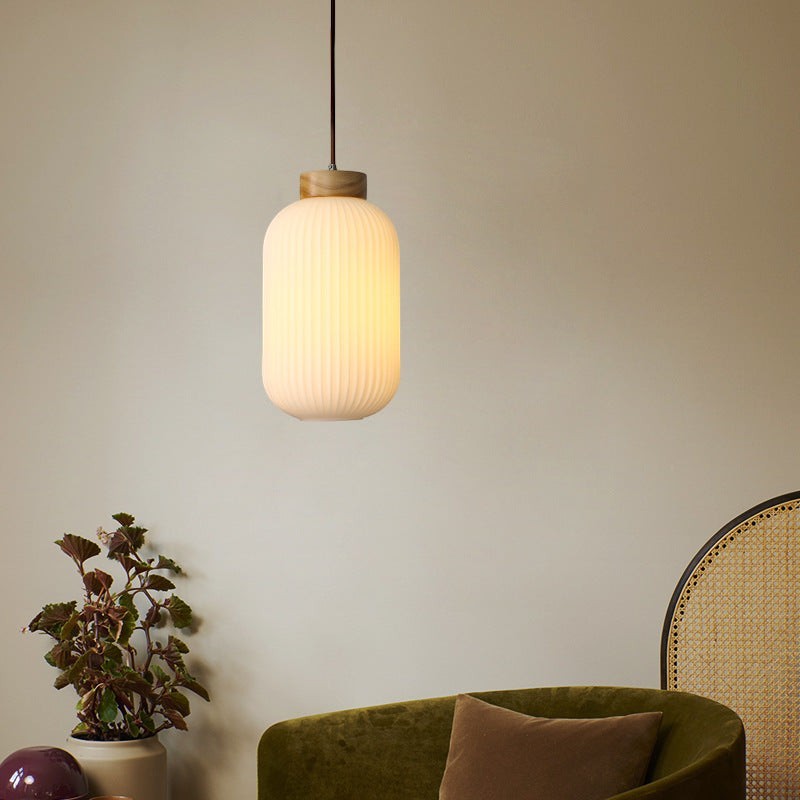 Suspension Lumeoo en bois et verre cannelé blanc diffusant une lumière douce dans un intérieur chaleureux