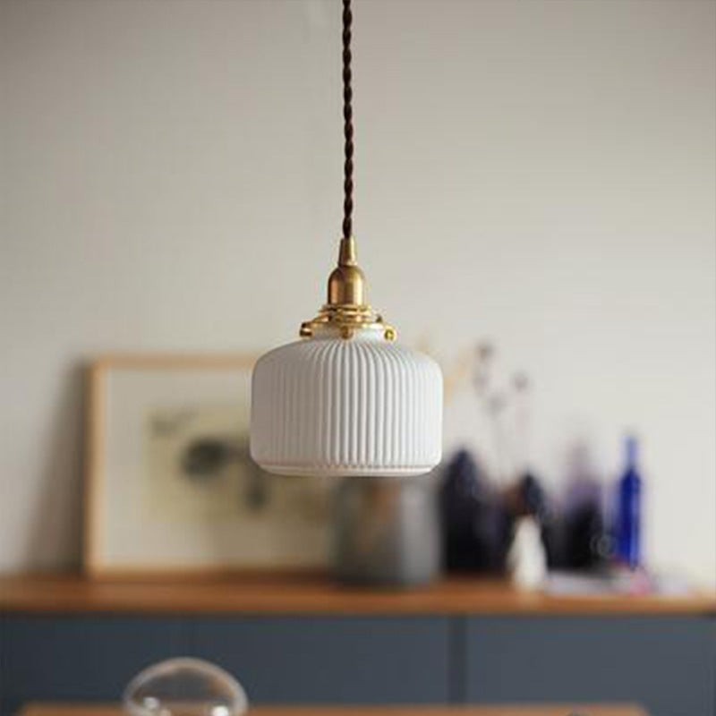 Suspension Lumeoo en céramique blanche cannelée avec douille en laiton doré et cordon torsadé pour une ambiance douce