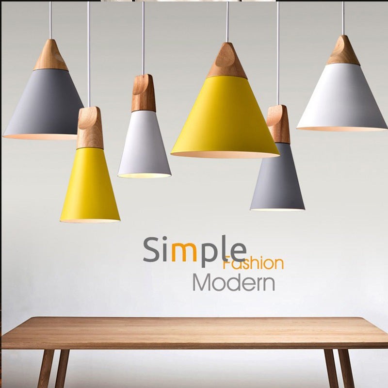 Suspensions coniques Lumeoo en aluminium coloré et bois naturel au design scandinave épuré au-dessus d'une table