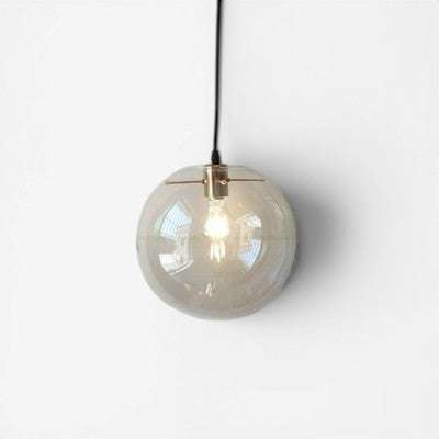 Suspension luminaire boule en verre transparent Lumeoo avec monture dorée pour un éclairage doux et élégant