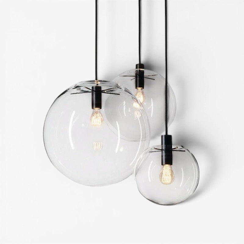 Suspension luminaire Lumeoo SPHERIA composée de trois boules en verre transparent avec douilles noires élégantes