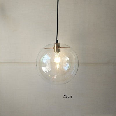 Suspension luminaire boule en verre transparent Lumeoo avec monture dorée pour un éclairage doux et élégant