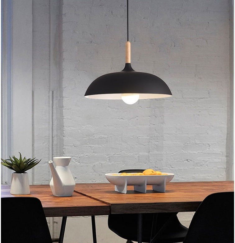 Suspension Lumeoo noire et bois au-dessus d'une table en bois dans une salle à manger moderne Image