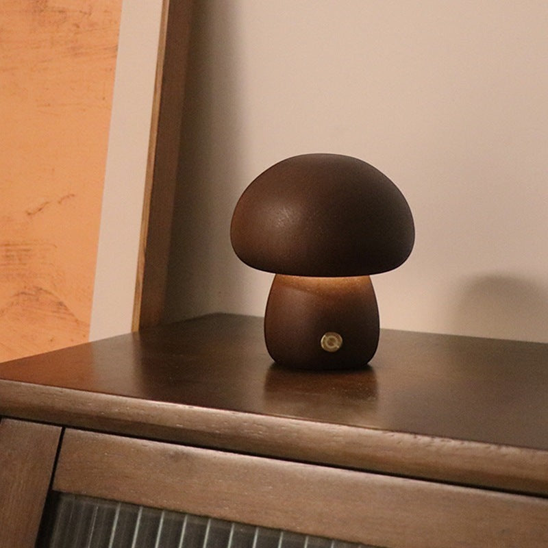 Veilleuse champignon Lumeoo en bois marron avec éclairage LED tactile rechargeable posée sur un meuble