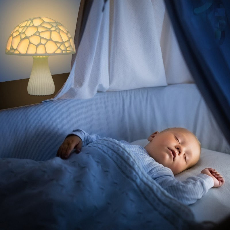 Veilleuse champignon Lumeoo LED 3D rechargeable diffusant une lumière douce et apaisante près d'un bébé endormi