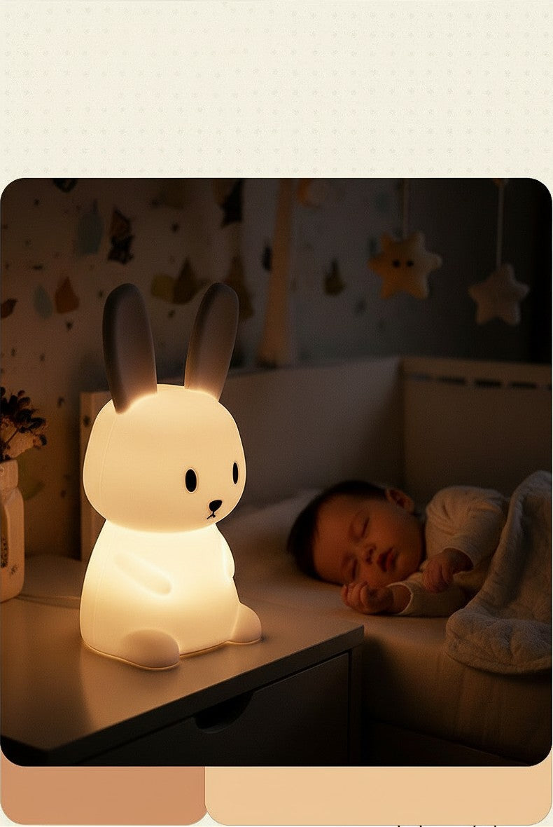 Veilleuse lapin Lumeoo en silicone souple diffusant une lumière LED douce près d'un bébé endormi dans son lit