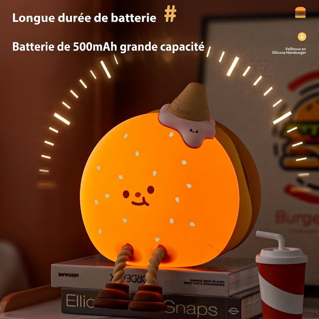 Veilleuse Lumeoo en silicone forme hamburger avec lumière douce orange pour chambre d'enfant posée sur des livres